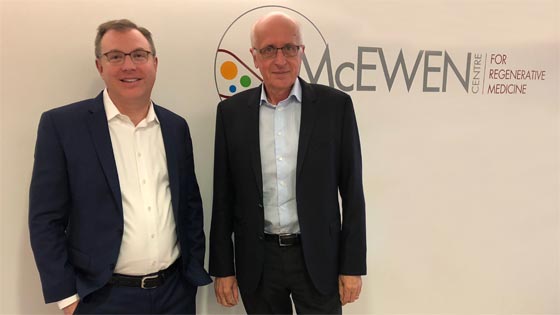 Pair standing in front of McEwen Centre sign