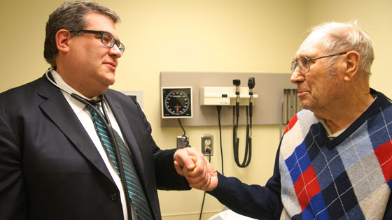 Image of Dr. Eric Horlick holding hands with patient, David McCallum