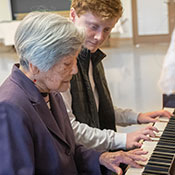 two people playing the piano