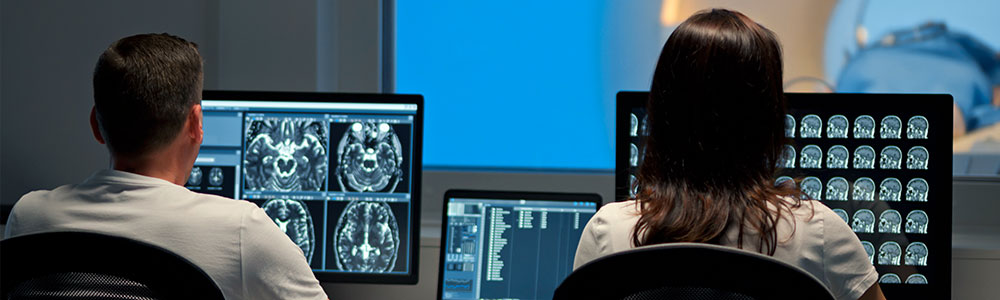 two people viewing the results of a CT scan