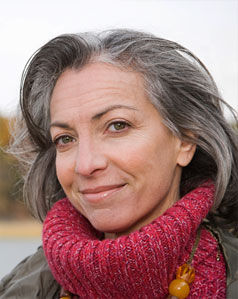 Portrait of woman with long greying hair wearing pink scarf outside