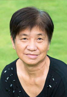 Portrait of woman with short hair and grass in background