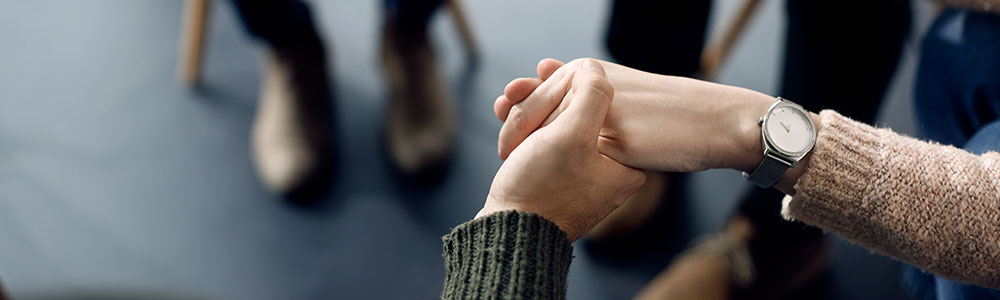two people holding hands at a support group
