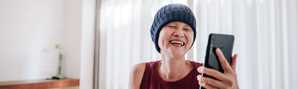 smiling person wearing a fleece hat indoors
