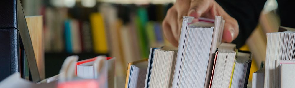 hand reaching for a book on a cart