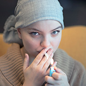 cancer patient lighting up a cigarette