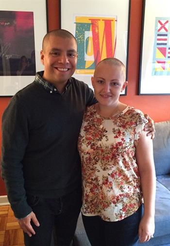 Emily with a shaved head standing with her husband