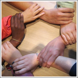 People holding each other's wrists to form a circle of hands 