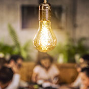 group of people brainstorming over a light lightbulb