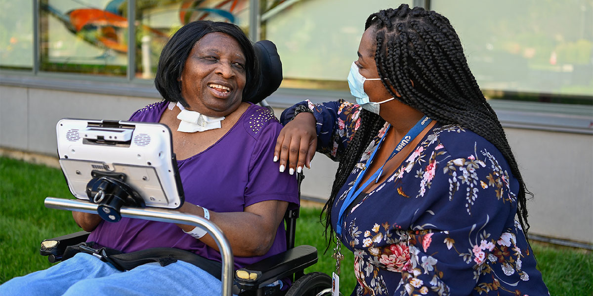 Wheelchair patient siting outside with UHN staff member