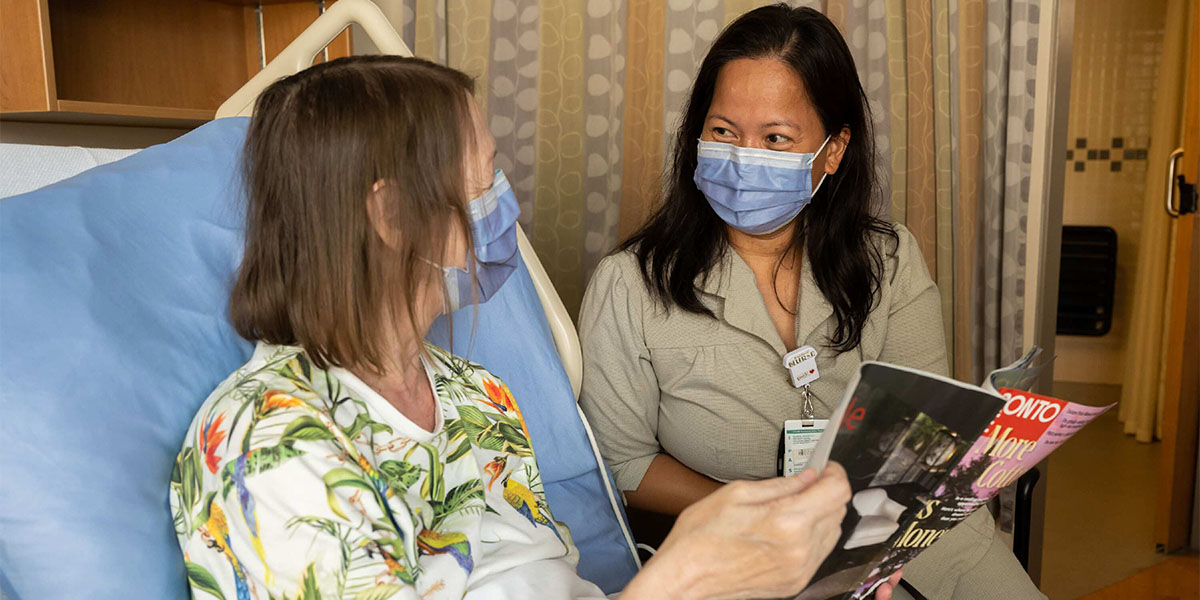 Patient reading a magazine with UHN staff