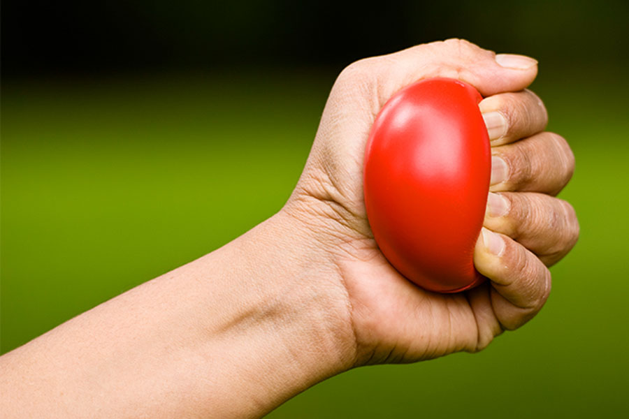 hand squeezing red ball