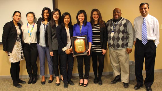 Image of winning team holding Dragons’ Den plaque along with Dr. Atul Humar and Segun Famure