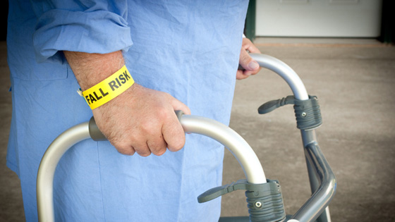 patient with fall risk bracelet using walker