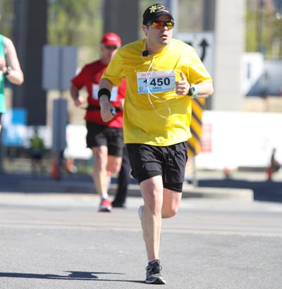 Greg running wearing yellow shirt 