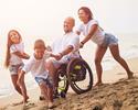family with wheelchair on beach 