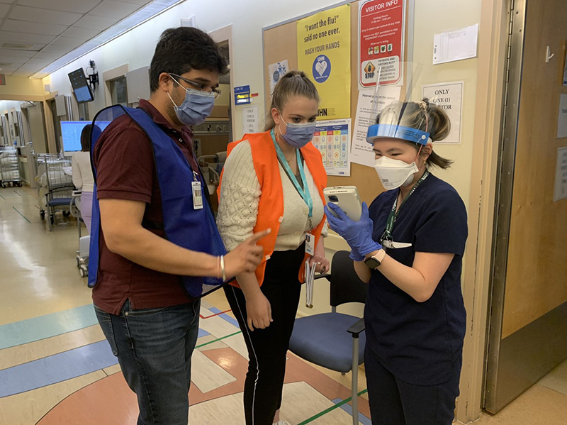 Guy in blue, woman in orange help nurse 