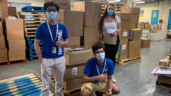 Emma Wosik and volunteers stand in front of boxes of supplies destined for Haiti