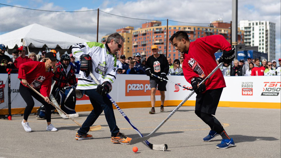 Adults playing road hockey