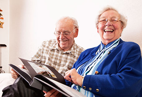 Image of two smiling seniors in their home.
