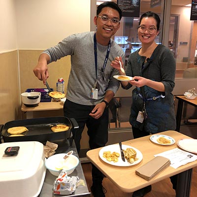 Pair of staff members serving pancakes 