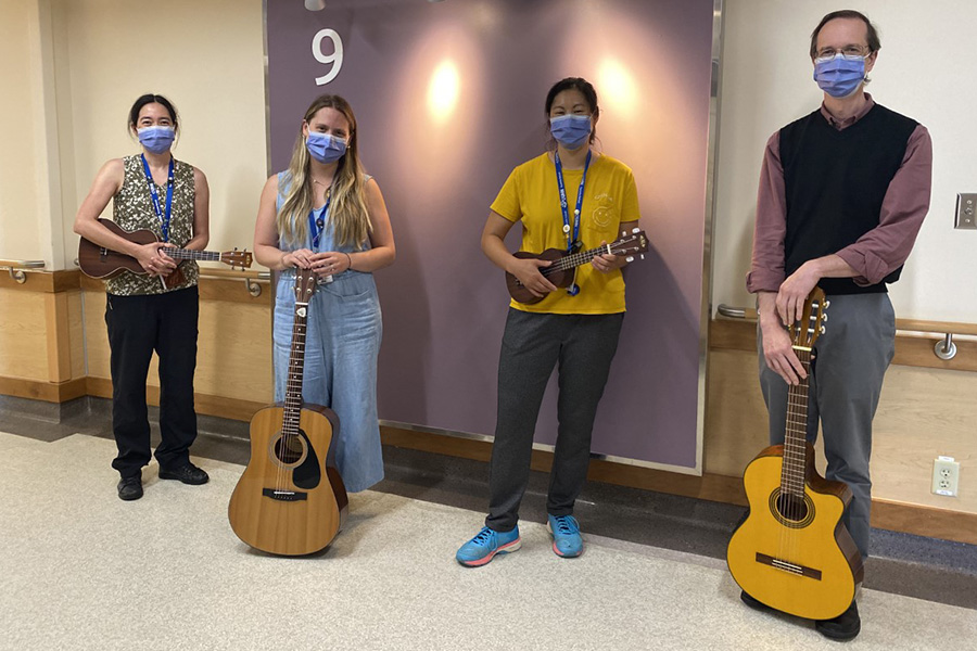 4 masked people with guitars/ukuleles 