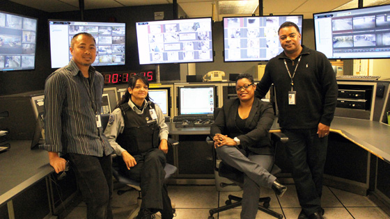 Image of four security team members in front of monitors 