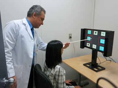 Dr. Ahmed Ebraheem uses a visual scanner to test a patient’s cognitive reflexes