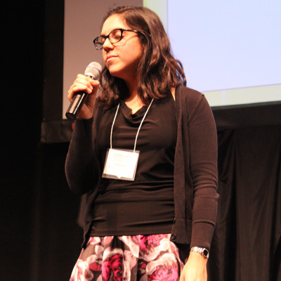 Image of SarahRose Black, standing on stage, singing with eyes closed