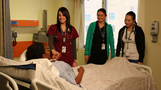 Main of nurses with patient at bedside 
