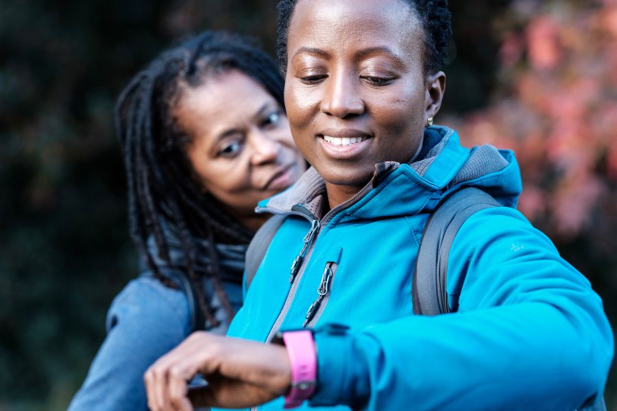woman checks smartwatch of senior man to prevent fall