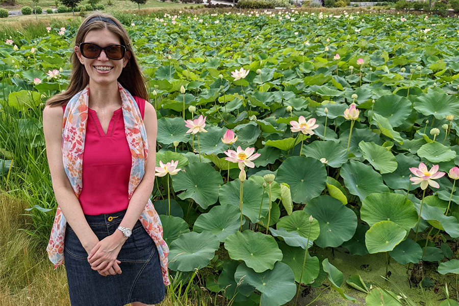 Woman smiling in front of a field of flowers