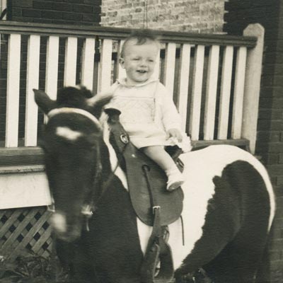 The patient, as a toddler, astride a horse 