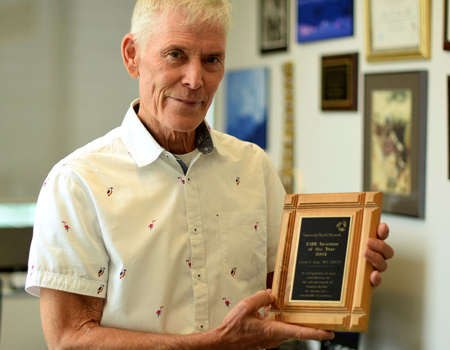 Dr. Kevin Kain holding award