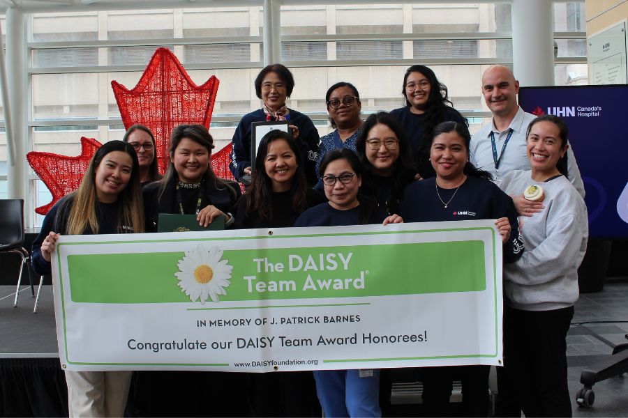 TeamUHN members standing together holding the Daisy Team Award