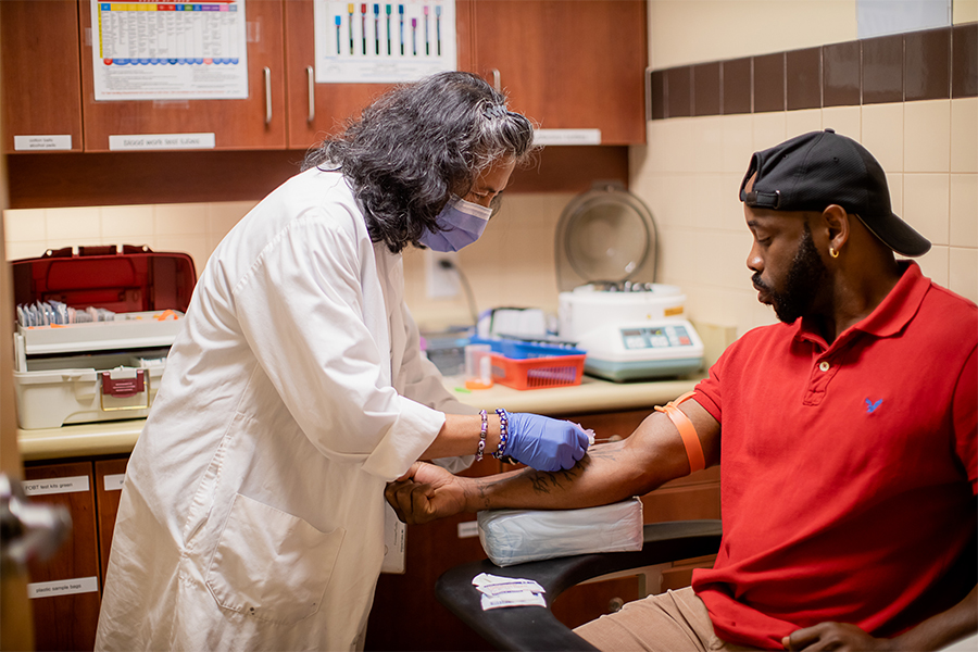 Man sitting down getting his blood drawn