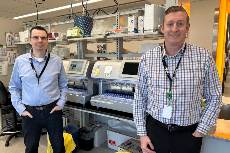 Michael Naglich and Dr. Jeffrey Kiernan standing in front of lab machines