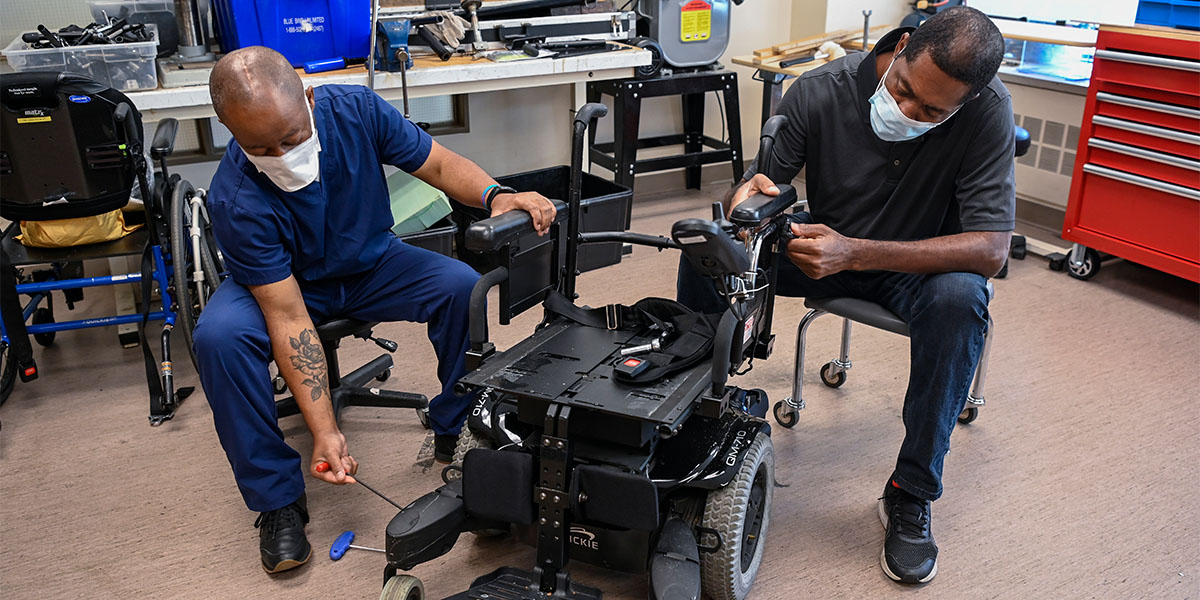 Workers building a wheelchair
