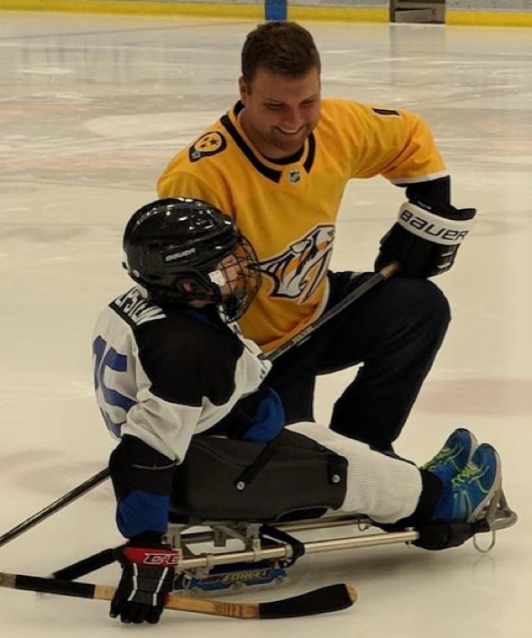 Cody on ice with child with disabilities