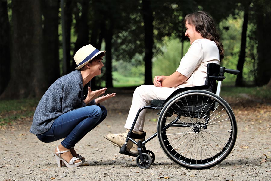 Woman talking to another woman in a wheelchair 