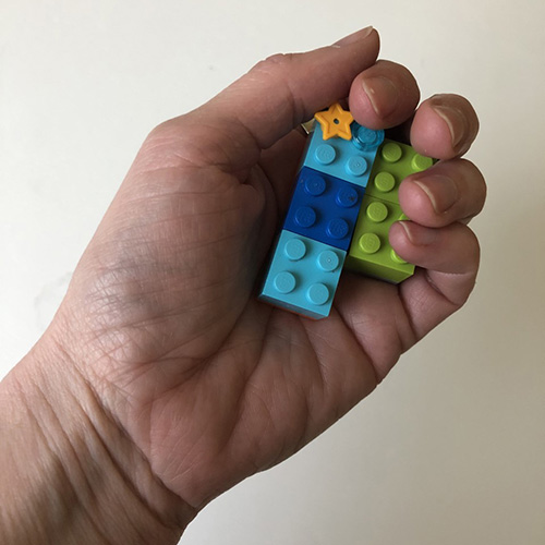 Erin’s hand holding LEGO