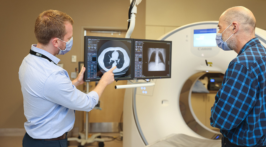 Dr. Michael McInnis, (L), a thoracic radiologist at UHN, explains a low-dose CT scan result to patient Edward Zielinski