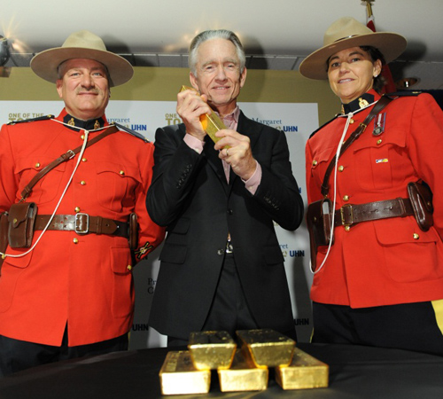 Image of Ian Telfer (center) and the six gold bars 